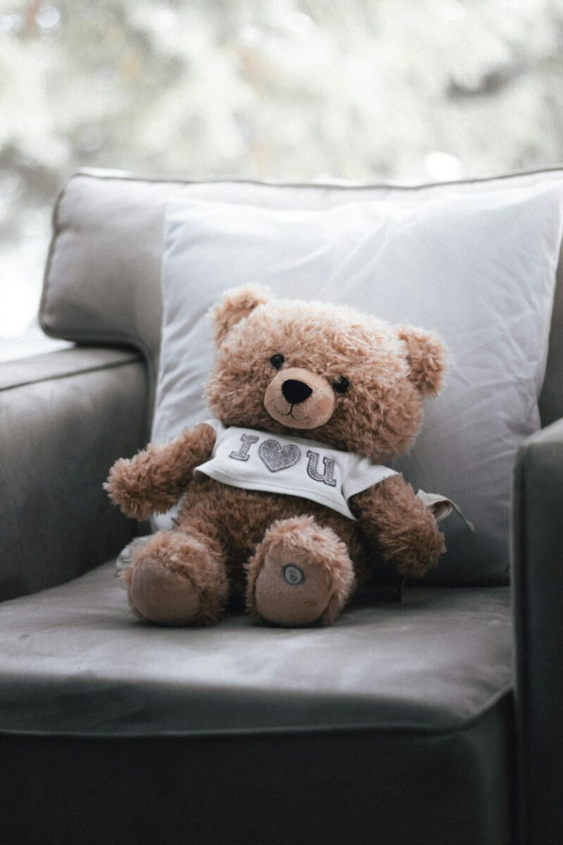 Brun bamse der sidder på en sofa
